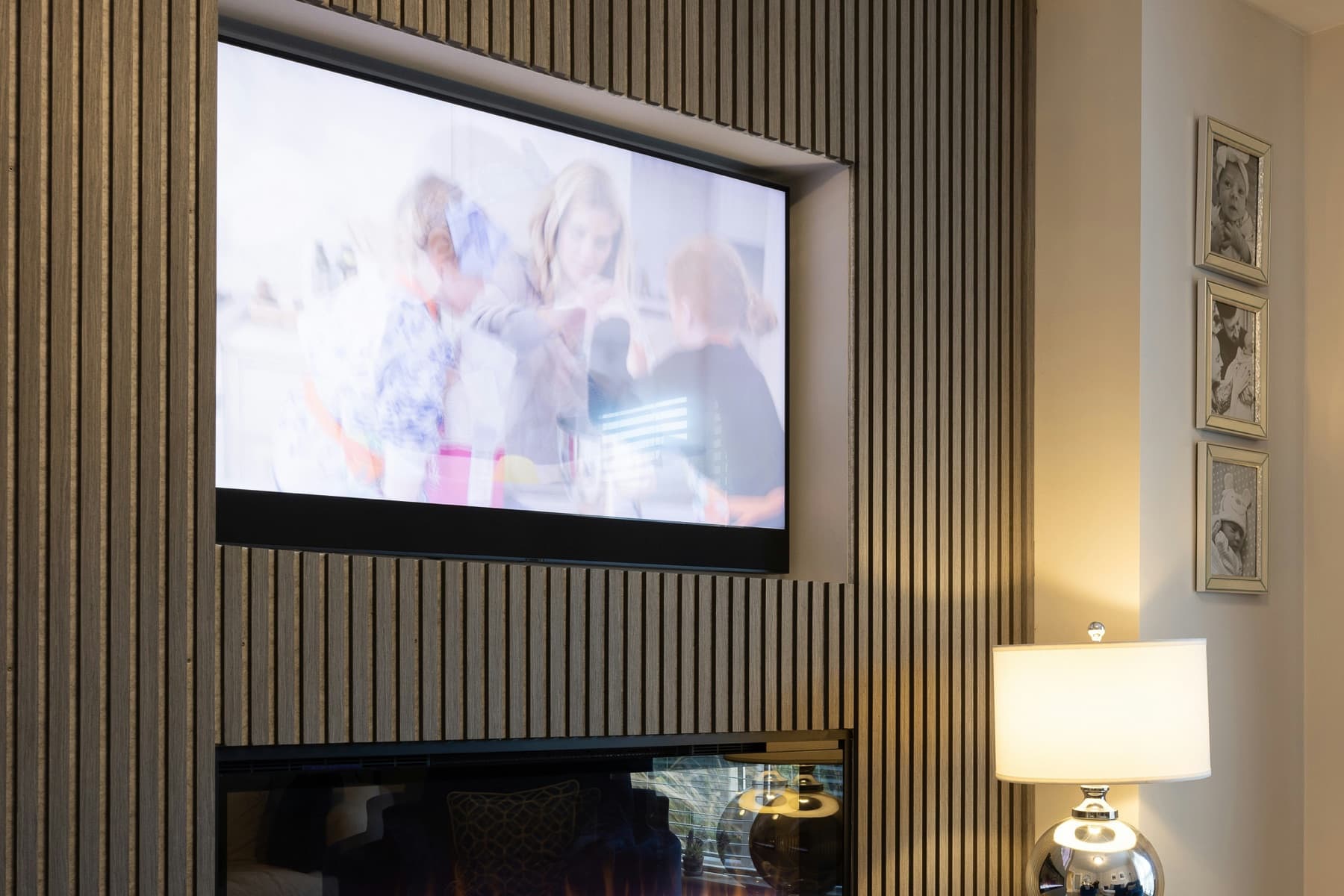 Wall-mounted television above a modern fireplace