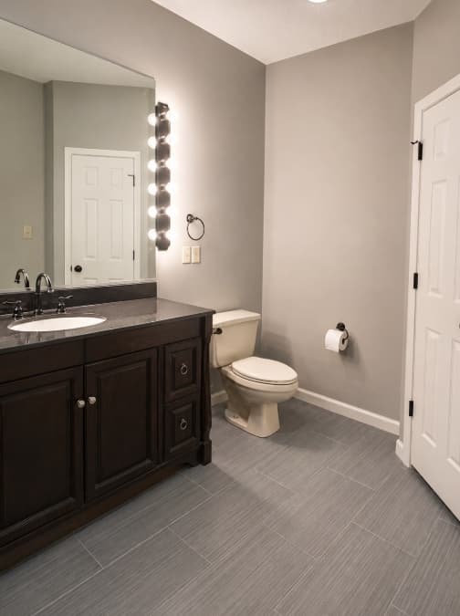 Finished gray bathroom with dark wood vanity