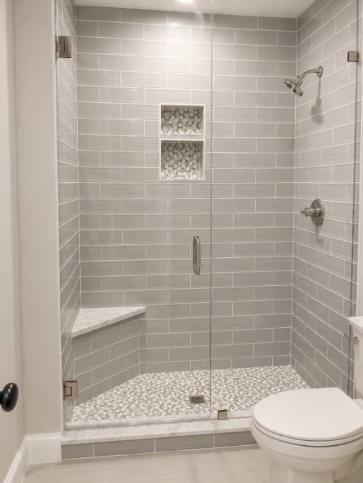 Gray subway tile shower with frameless glass enclosure