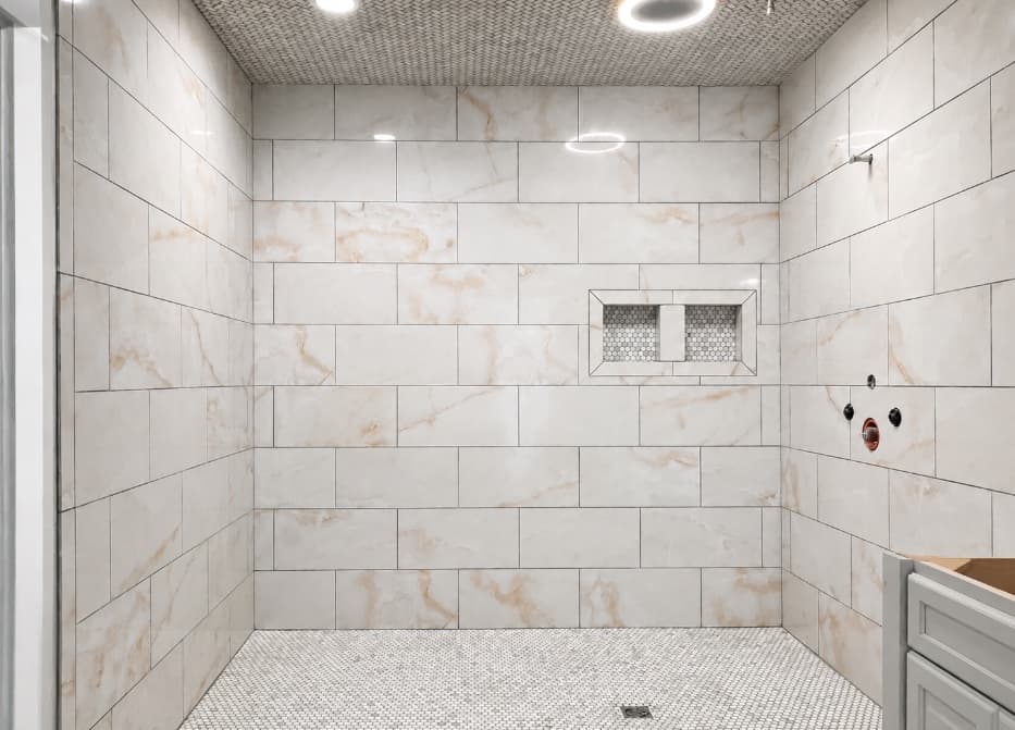 Large walk-in shower with marble-look wall tile and mosaic floor