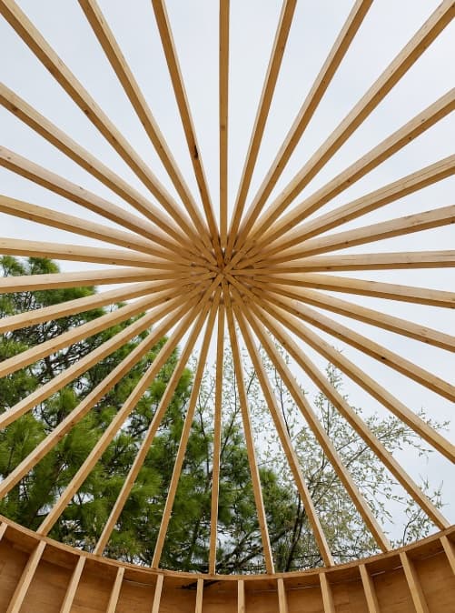 Radial wood roof framing viewed from inside a round structure